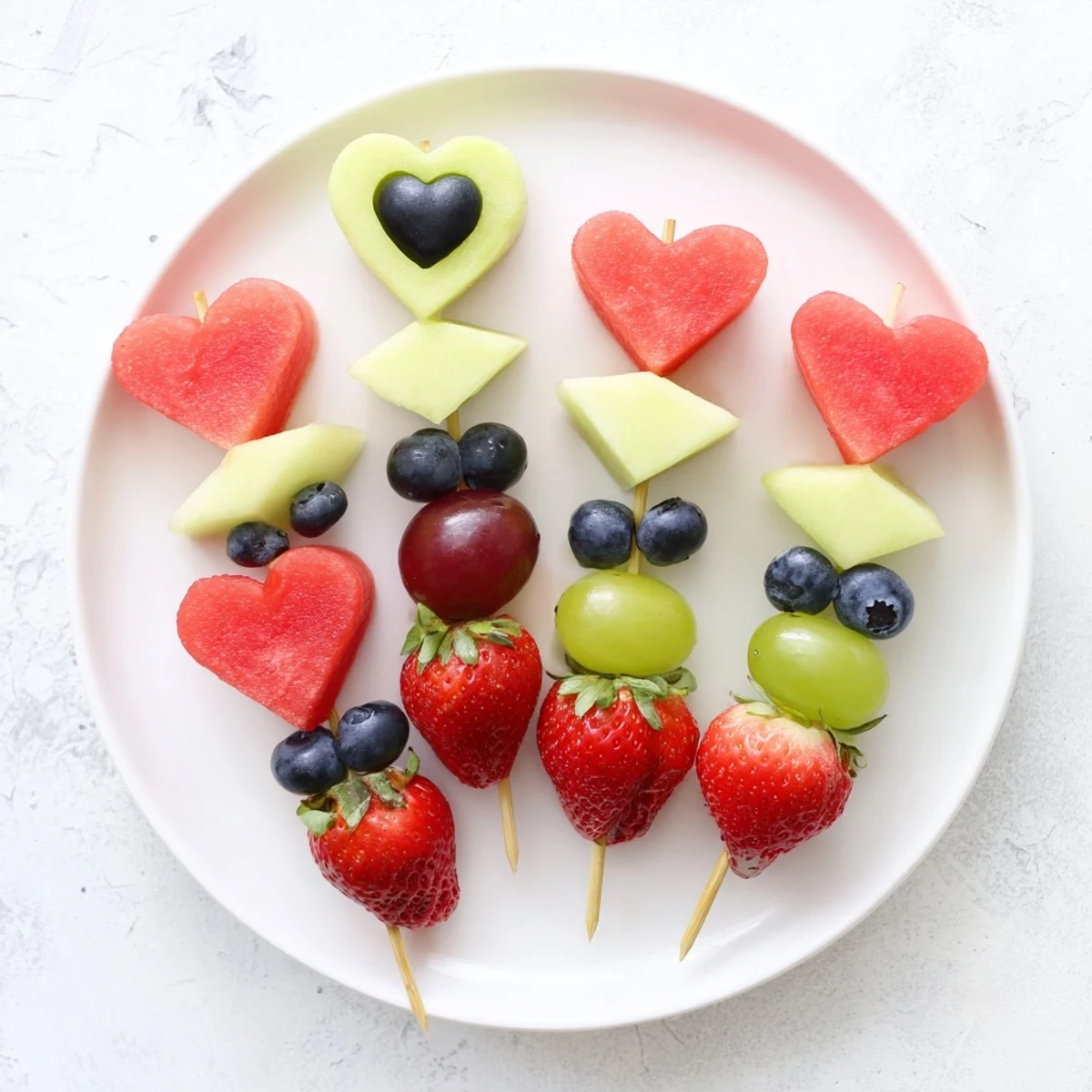 Vibrant Berry Good Heart Fruit Skewers feature colorful heart-shaped melons and sweet berries on skewers.