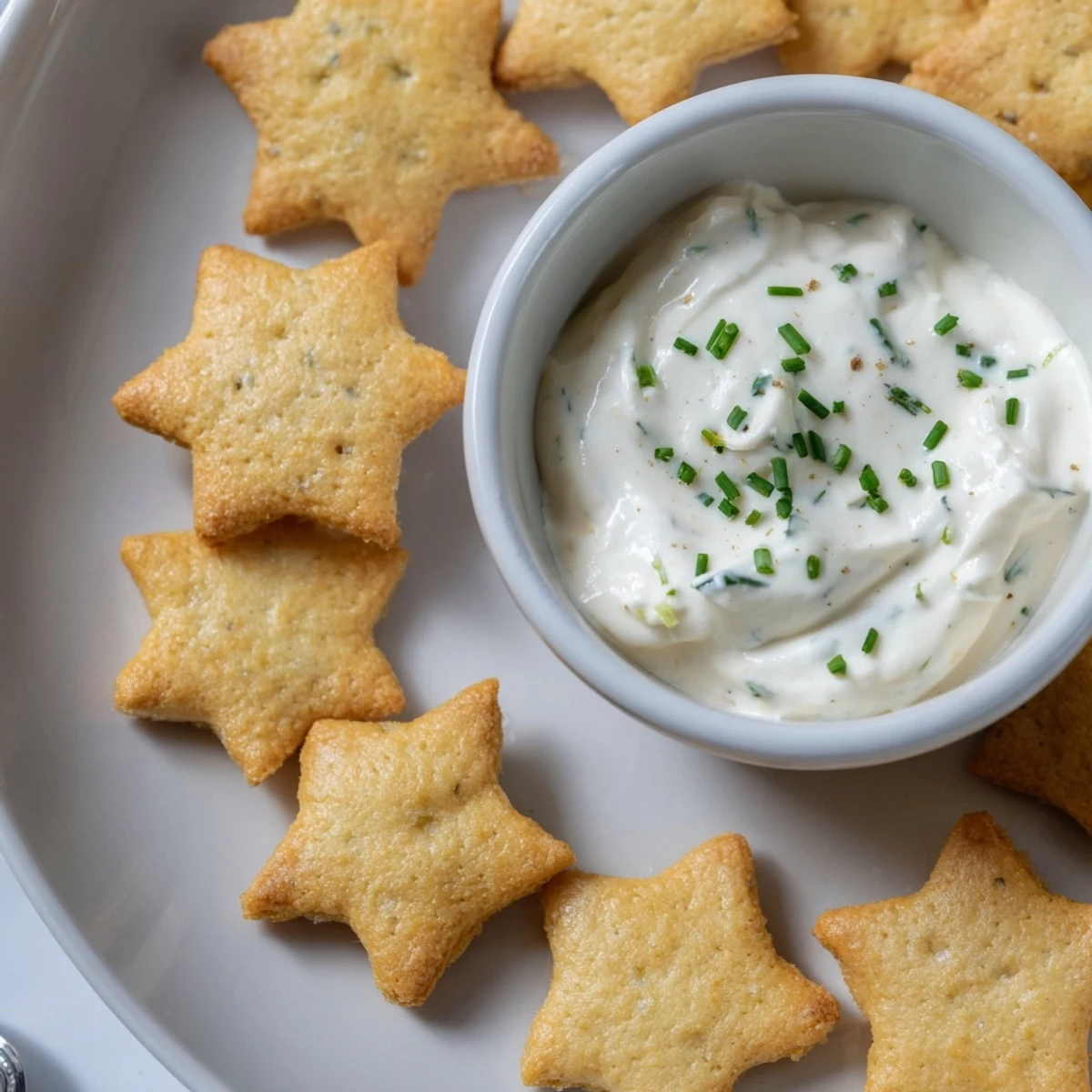 Festive holiday crackers, fresh from the oven, with a creamy dip center displayed prominently.