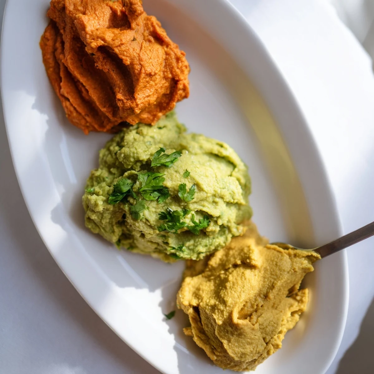 A visually appealing platter of Dip Trio featuring three homemade, colorful dips ready to share.