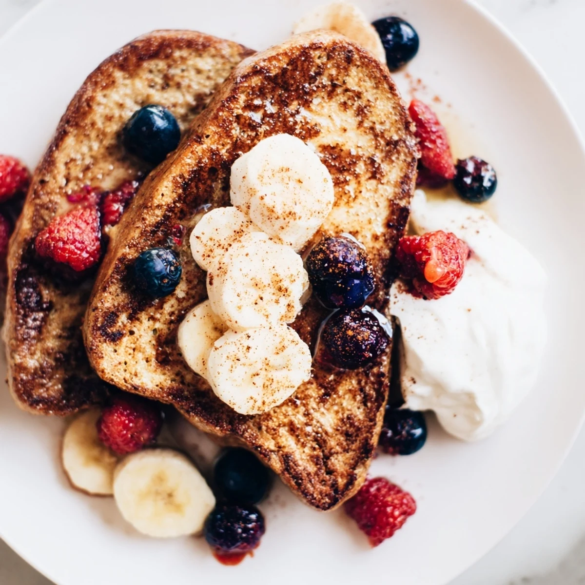 Golden-brown protein French toast, served with fresh berries, offers a tasty, healthy breakfast.
