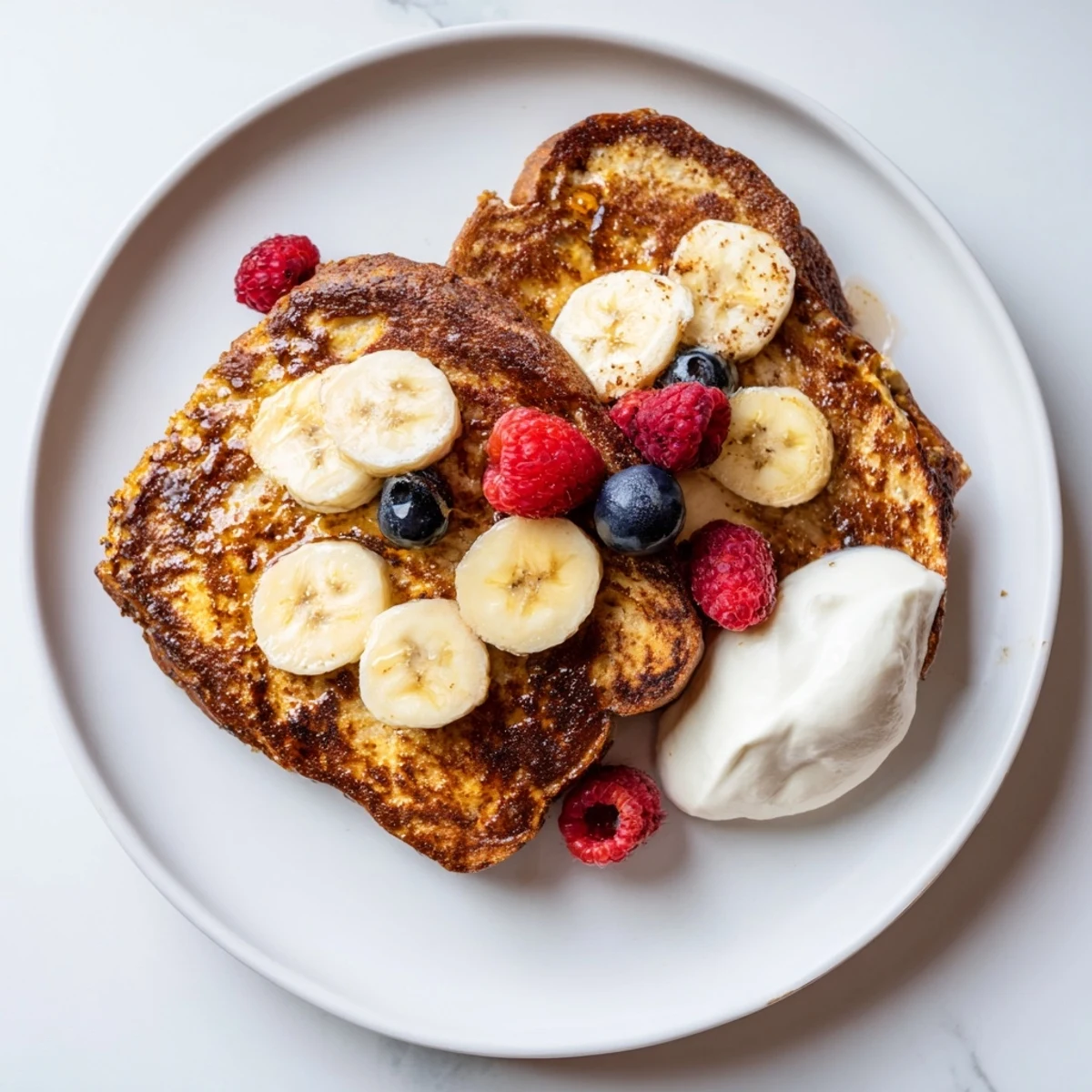 Warm, fluffy protein French toast awaits, drizzled with maple syrup; the perfect post-workout treat.