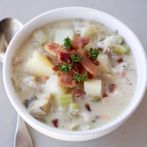 Creamy New England Clam Chowder with tender potatoes and smoky bacon, ready to serve.