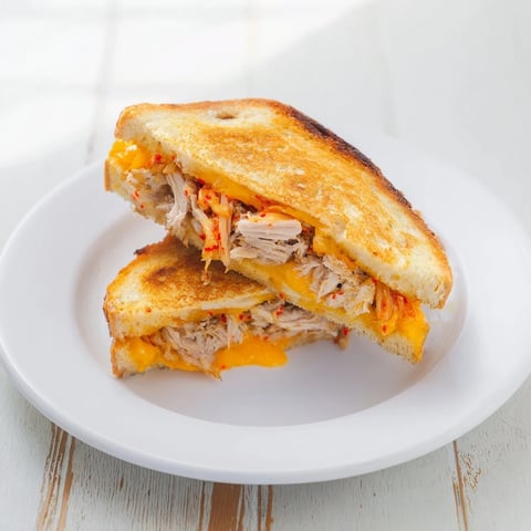 Golden, melty Kimchi Turkey & Cheddar Toasted Grilled Cheese, with tangy kimchi and savory turkey.