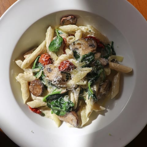 Golden mushrooms and sun-dried tomatoes highlight this Creamy Sun-Dried Tomato Mushroom Penne Skillet, ready to serve.
