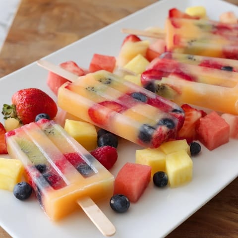 Summer Popsicle Board brimming with colorful popsicles, fresh fruit, and fun toppings for summer treats.