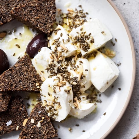 Glistening mozzarella and dark rye star in this "Black and White Formal Affair" appetizer arrangement, ready to be enjoyed.