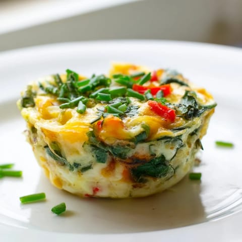 A close-up of savory mini crustless quiches, showcasing fluffy eggs and vibrant spinach fillings.