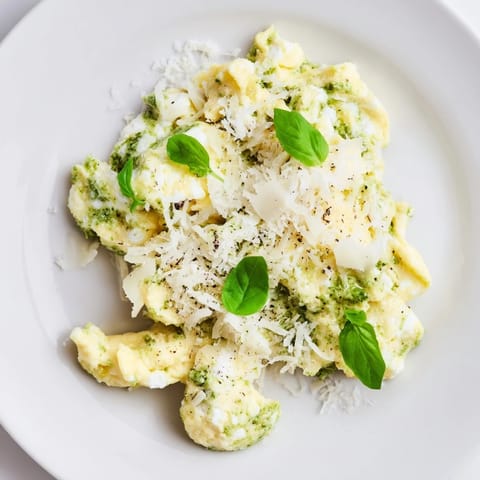 Scrumptious Pesto Cottage Cheese Eggs, ready to eat, served with fresh basil and crusty toast for a filling brunch.