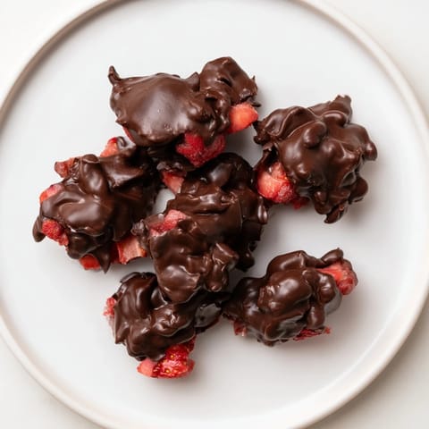 Freshly dipped Strawberry Yogurt Clusters, showing the chocolate's glossy, crisp texture, a perfect dessert.