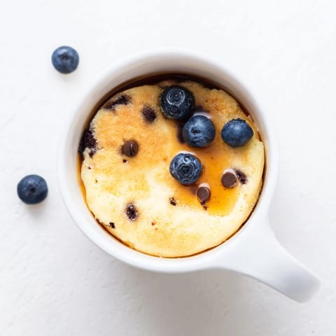 Golden brown Microwave Mug Pancake rising perfectly inside a white ceramic mug for a quick breakfast.  