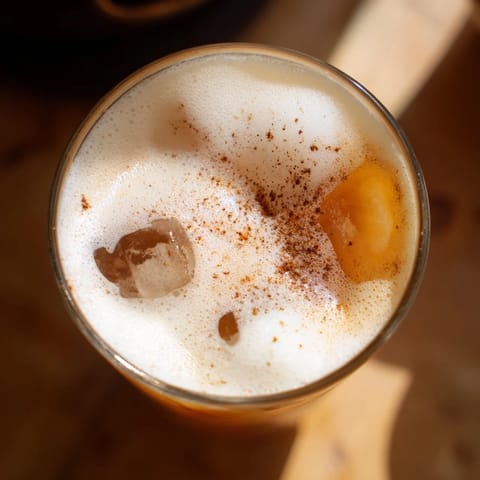 A frosty glass of Iced Chai Tea with Cold Foam, aromatic spices mingling with creamy foam for a refreshing afternoon treat.