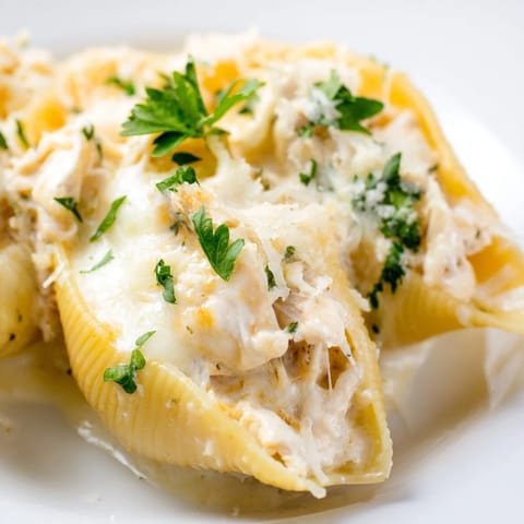 Golden, cheesy Chicken Alfredo Stuffed Shells served warm from the oven with a side salad.  