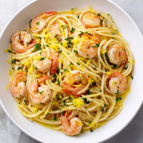 Juicy shrimp and garlicky pasta twirl in a skillet with a spritz of lemon and a pinch of red pepper flakes.  