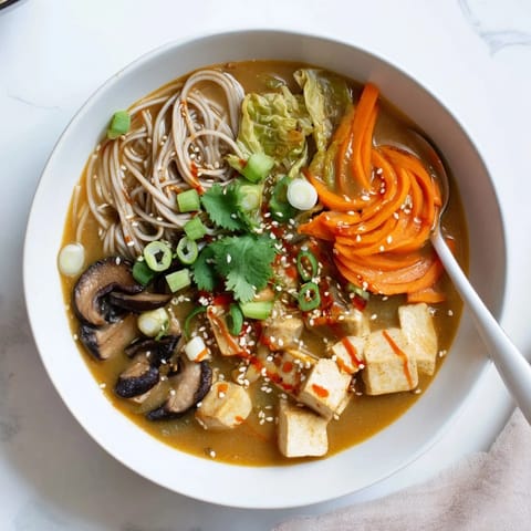 Steaming Ginger-Miso Winter Soup in a rustic bowl, featuring silken tofu and soba noodles for a nourishing Japanese-inspired meal.