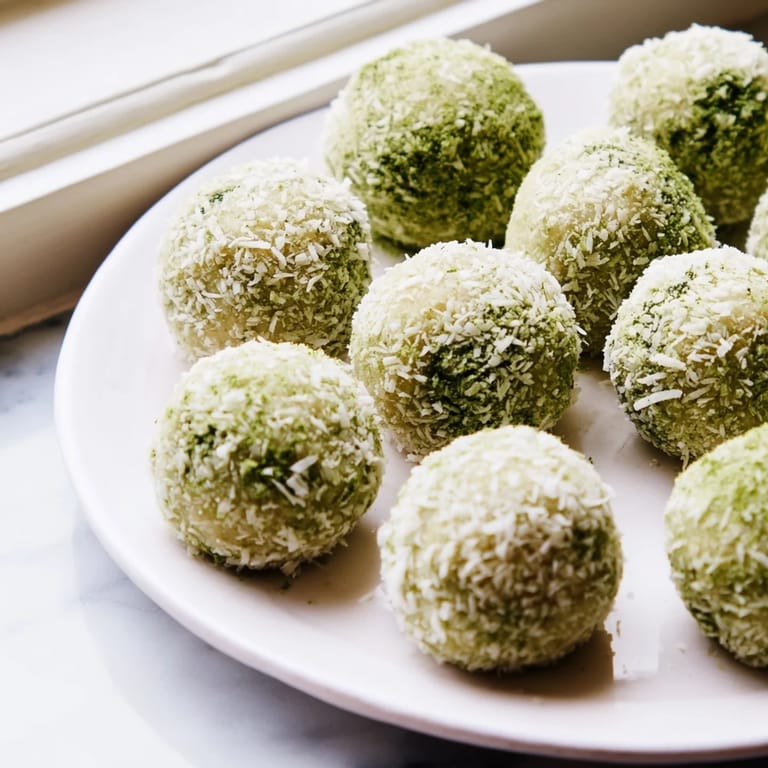 Enjoy these keto-friendly coconut matcha snowball fat bombs, the perfect chilled, bite-sized dessert!
