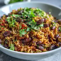Spanish Rice and Beans in a pot with fresh cilantro garnish, showcasing vibrant colors and hearty texture.  